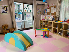 子育てサロンあみあみ部屋　子育て交流サロンのお部屋の中の様子です。乳児用の滑り台は子どもたちに人気です。