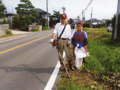 県道は大型車も通ることが多いので奥様も事故防止のため片付けを兼ねて作業する