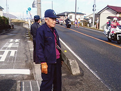 清掃できれいになった県道（東日本駅伝コース）を走るランナーを応援する遠藤さん