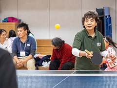 とりで塾で子どもたちと卓球をするボランティアスタッフ