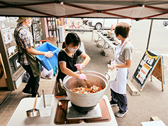 大きい鍋でカレーの具材を炒めている様子