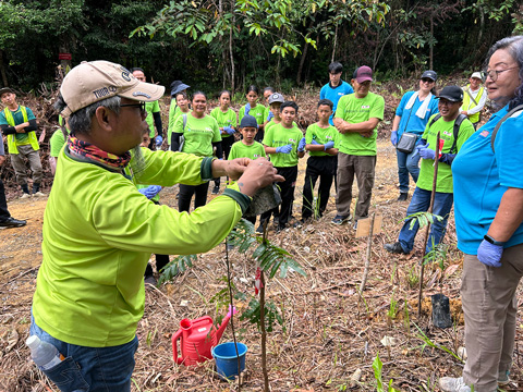 熱帯雨林再生活動の現場を小学生と先生に見学してもらう