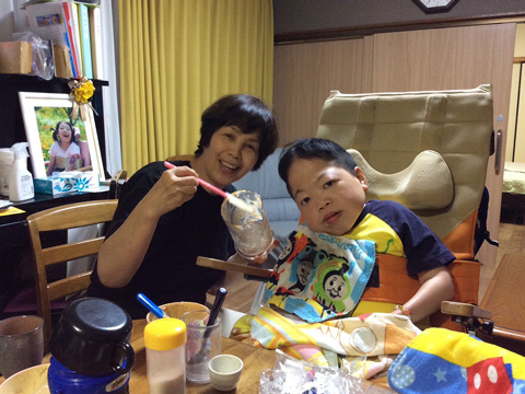 開設初期　重度障がい者の食事介助を行う泰子さん