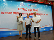 当団体代表（向かって右）ベトナム奨学金需要式にて奨学生から感謝の気持ちとして果物を受け取る様子（左は事務局長）